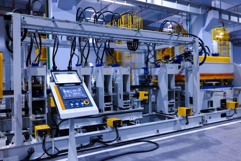 Industrial control panel and automation equipment connected to an electric motor powering a conveyor system.